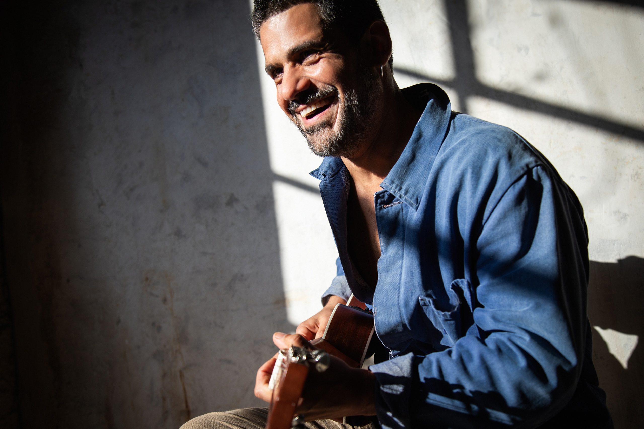 Foto del cantante Mannarino che suona la chitarra